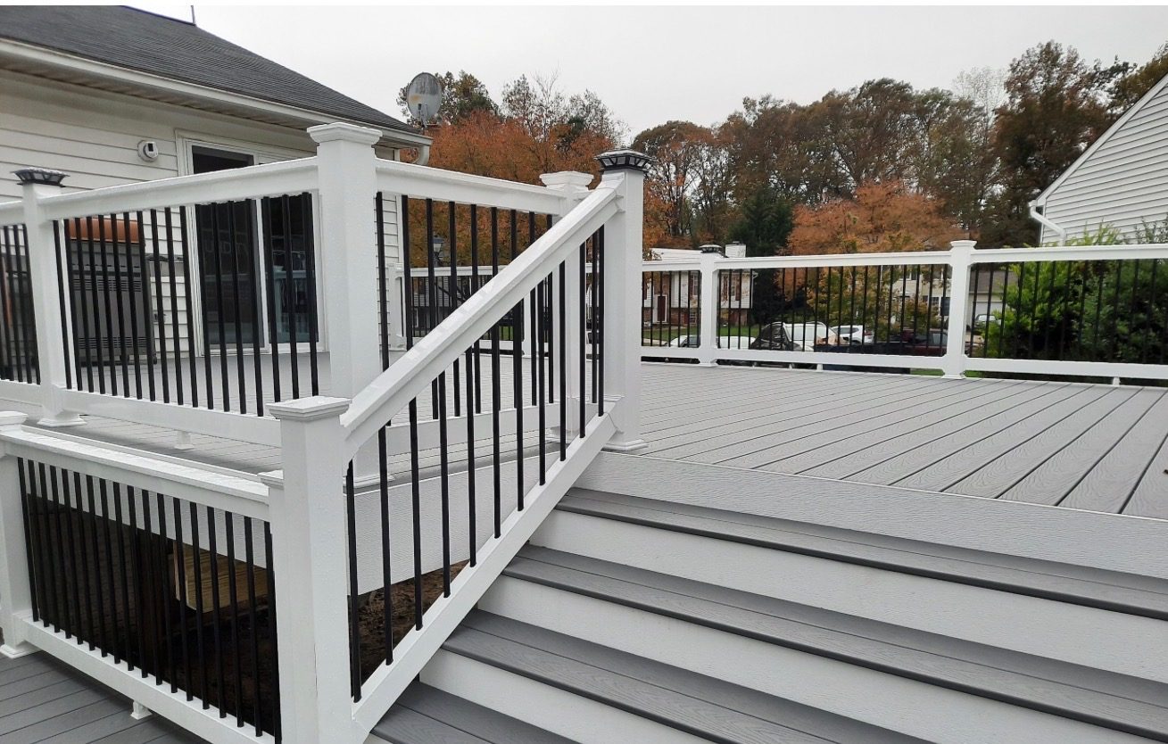 Composite deck built by TNK with white railings and black balusters